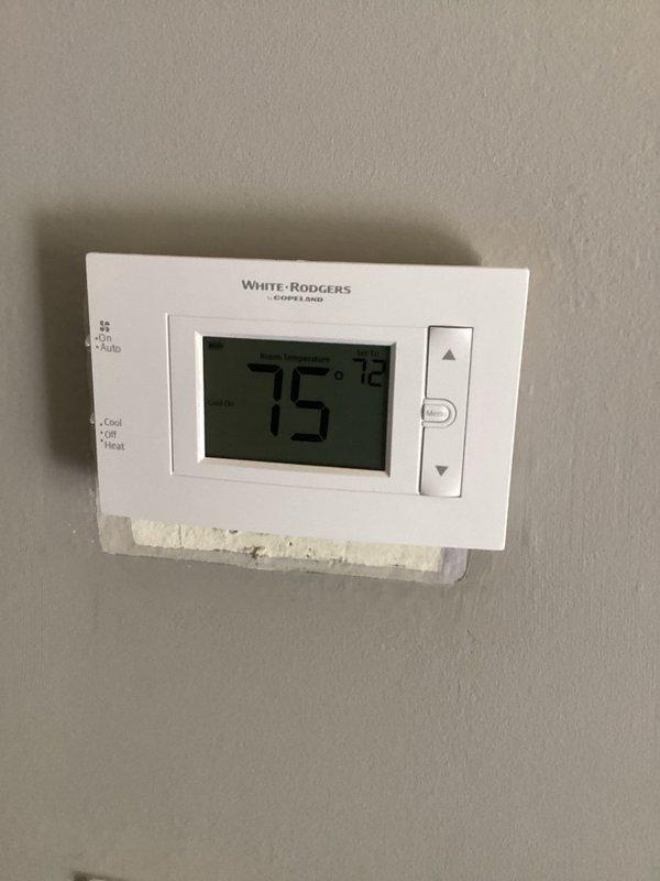 Responded to service call for non-functional thermostat. Upon arrival, discovered severe electrical damage to ceiling-mounted wiring with evidence of arcing, charring, and burn-through at wire connection point above thermostat location. Replaced damaged White-Rodgers digital thermostat (model 80P21-0401) with new non-smart traditional thermostat per customer request. Repaired compromised electrical wiring, secured all connections, and verified proper system operation and temperature control functionality.