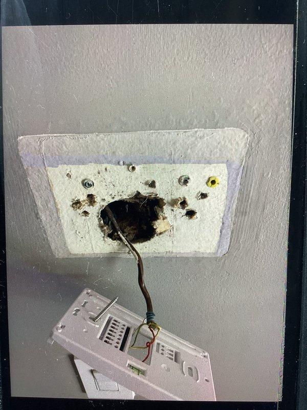 Responded to service call for non-functional thermostat. Upon arrival, discovered severe electrical damage to ceiling-mounted wiring with evidence of arcing, charring, and burn-through at wire connection point above thermostat location. Replaced damaged White-Rodgers digital thermostat (model 80P21-0401) with new non-smart traditional thermostat per customer request. Repaired compromised electrical wiring, secured all connections, and verified proper system operation and temperature control functionality.