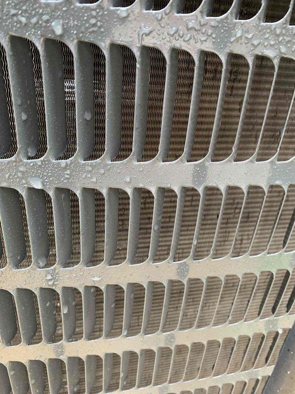 Completed comprehensive tune-up and maintenance service on Goodman HVAC system located at rear of property. Performed standard preventive maintenance protocol including inspection of heat exchanger, condenser coil with aluminum fins, and refrigerant lines. System was operational upon arrival and showed normal condensation patterns consistent with active cooling cycle, with unit displaying appropriate frost accumulation on components indicating proper refrigerant flow and heat exchange function.