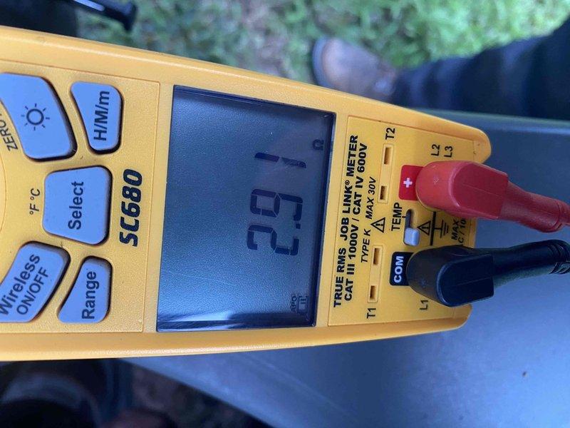 Responded to no cooling complaint on 10+ year old system located at ground level in basement area. Diagnosed failed contactor on outdoor condensing unit preventing compressor operation. Tested and confirmed contactor coil reading 6.3 ohms, indicating electrical failure. Removed defective contactor and advised customer to shut off AC system and leave fan running until replacement part could be installed to prevent further system damage.
