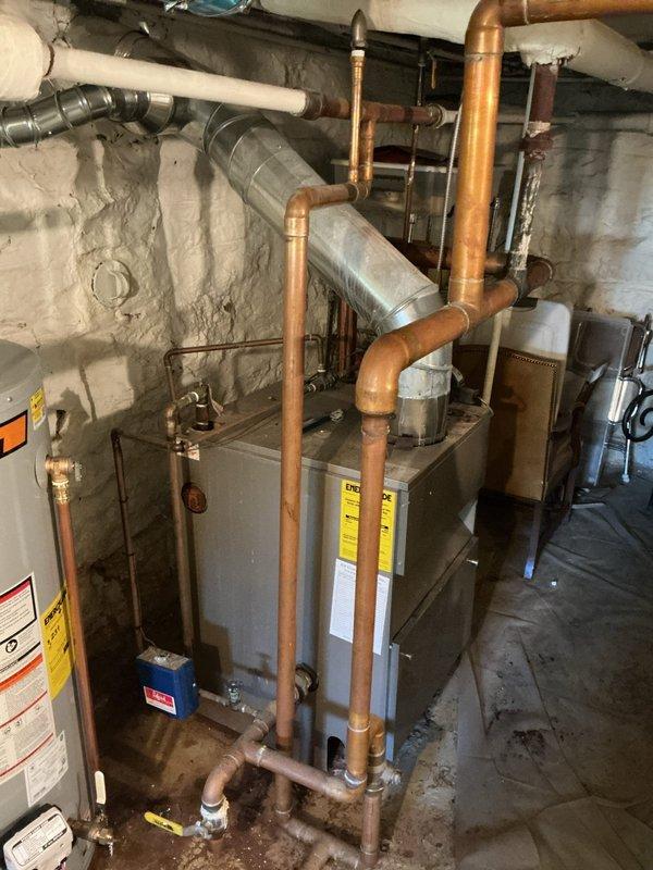 Responded to failed water heater inspection for permit #26-008124 regarding inadequate combustion air supply for fuel-burning appliances. Assessed basement mechanical room containing furnace and water heater to determine compliance with combustion air requirements. Documented existing conditions showing HVAC equipment and water heater installation in confined utility space with limited ventilation. Per inspector requirements, combustion air must be supplied from adjacent room, another story, or directly from exterior if not adequately provided from the equipment room. Photographed current setup including all mechanical equipment, piping configurations, and surrounding structural elements for permit compliance documentation.