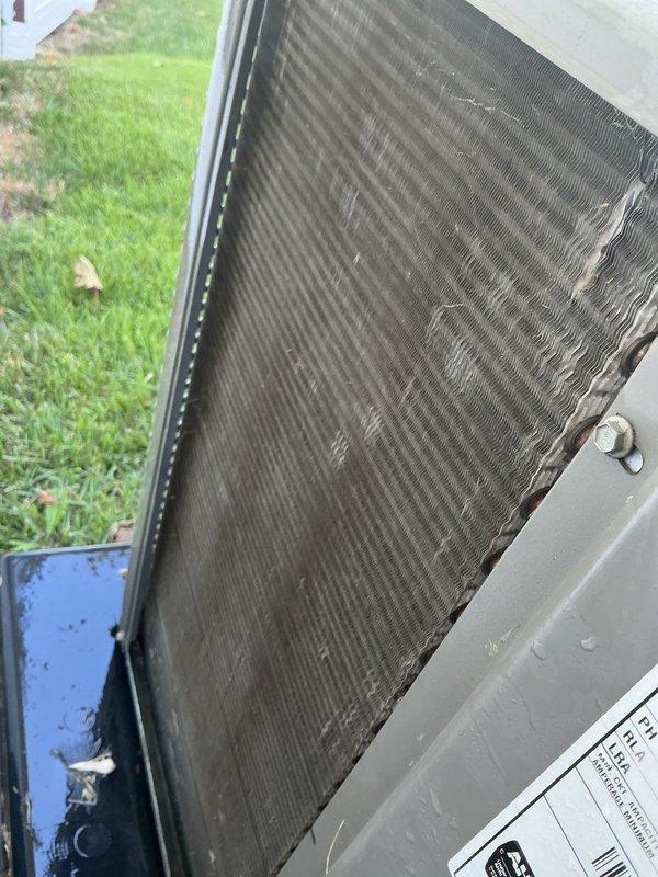 # HVAC Tune-Up Completed

Performed comprehensive air conditioning tune-up on single outdoor condensing unit located on side of residence. Upon arrival, conducted visual inspection revealing significant accumulation of dirt, dust, and debris throughout condenser coil fins, restricting airflow and reducing system efficiency. Thoroughly cleaned condenser coil using appropriate methods to remove environmental buildup from fin surfaces. Inspected attic-mounted air handler and associated ductwork, noting insulated refrigerant lines and metal supply ducts in satisfactory condition. Verified system operation following cleaning procedures. Unit returned to normal operating parameters with improved airflow through condenser coil. Documented pre-service and post-service conditions with photographic evidence showing extent of debris accumulation prior to cleaning.