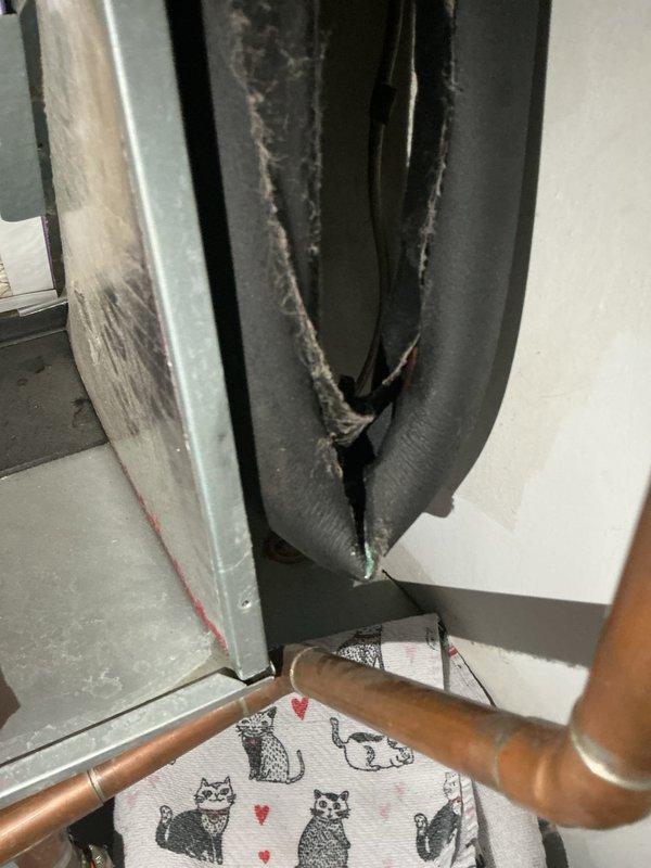 Responded to service call for water leakage from rooftop AC unit dripping onto hot water heater below. Upon inspection, discovered severely deteriorated flexible ductwork insulation with torn sections and fraying around air handler components, along with compromised condensate drainage system. Addressed water leak issue by clearing condensate drain line obstruction and verified proper drainage flow. Documented extensive insulation damage on ductwork and copper refrigerant lines requiring replacement to prevent future moisture issues and maintain system efficiency.