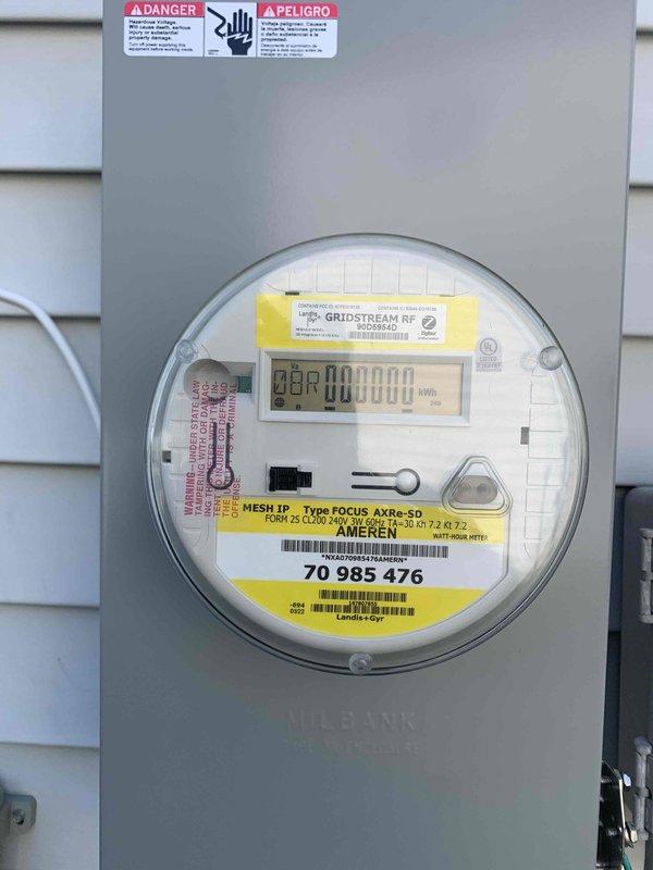 Completed electrical site assessment for Generac generator installation at primary residence with planned follow-up evaluation at secondary location. Documented existing electrical service configuration including digital mesh network meter (Ameren GridStream RF, Form 2S CL200) and main service panel mounted on exterior vinyl siding, and surveyed basement/crawl space infrastructure including existing electrical conduit routing, PVC plumbing lines, and available pathways through floor joists for potential generator transfer switch wiring and fuel line installation.