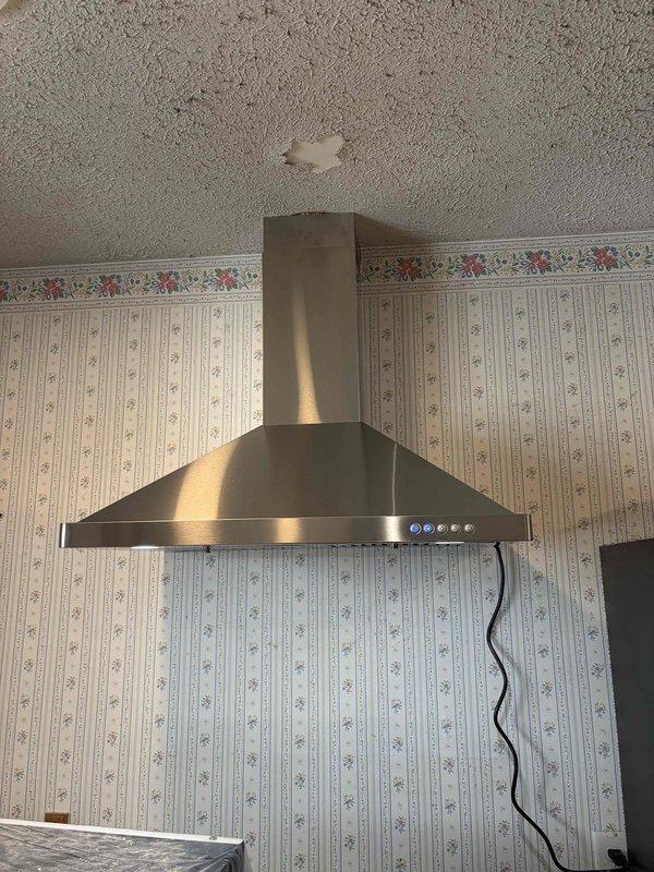 Returned to complete electrical installation for kitchen range hood as part of ongoing HVAC and lighting project. Completed wiring and power connection for stainless steel chimney-style range hood unit, ensuring proper electrical supply to ventilation system, LED lighting, and control panel. Verified all electrical connections were secure and hood controls functioning properly, including multi-speed fan settings and integrated lighting features. Installation completed successfully with unit fully operational.