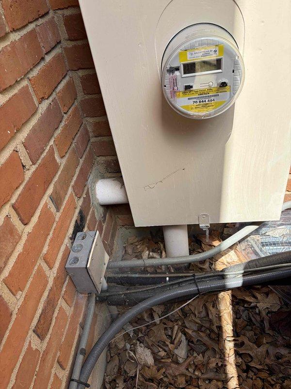 # Electrical Maintenance - Home Audit

Completed comprehensive electrical system inspection of residential property, evaluating both exterior service entrance equipment and interior main distribution panel. 

Exterior assessment examined the electrical meter installation mounted on brick wall, including weatherproof enclosure, digital meter unit, and associated conduit system. Verified proper mounting and physical condition of meter housing, noting minor weathering consistent with outdoor exposure. Inspected two white PVC conduit runs extending from meter base, confirming adequate protection for service conductors. Evaluated small gray junction box adjacent to meter installation. Documented accumulation of debris around foundation area near electrical equipment.

Interior inspection focused on main electrical panel with cover removed for detailed examination. Assessed circuit breaker arrangement in dual-column configuration and verified proper installation of breakers. Examined main se