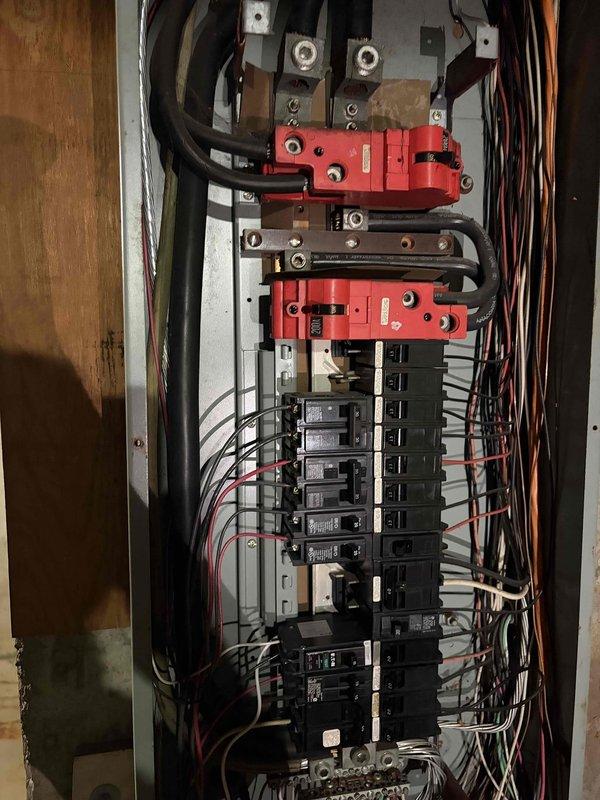# Electrical Maintenance - Home Audit

Completed comprehensive electrical system inspection of residential property, evaluating both exterior service entrance equipment and interior main distribution panel. 

Exterior assessment examined the electrical meter installation mounted on brick wall, including weatherproof enclosure, digital meter unit, and associated conduit system. Verified proper mounting and physical condition of meter housing, noting minor weathering consistent with outdoor exposure. Inspected two white PVC conduit runs extending from meter base, confirming adequate protection for service conductors. Evaluated small gray junction box adjacent to meter installation. Documented accumulation of debris around foundation area near electrical equipment.

Interior inspection focused on main electrical panel with cover removed for detailed examination. Assessed circuit breaker arrangement in dual-column configuration and verified proper installation of breakers. Examined main se