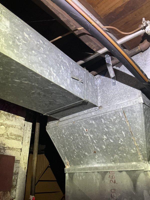 Responded to service call for air conditioning system making noise since April maintenance inspection. Performed diagnostic evaluation of 10-year-old outdoor unit located at side of house. Inspected ductwork system in basement/utility area, examining metal duct connections, joints, and mounting hardware for loose components or vibration points. Checked refrigerant lines, supports, and hangers throughout the system. Identified and addressed noise source, ensuring all ductwork properly secured and system operating quietly. Unit tested and confirmed normal operation upon completion.