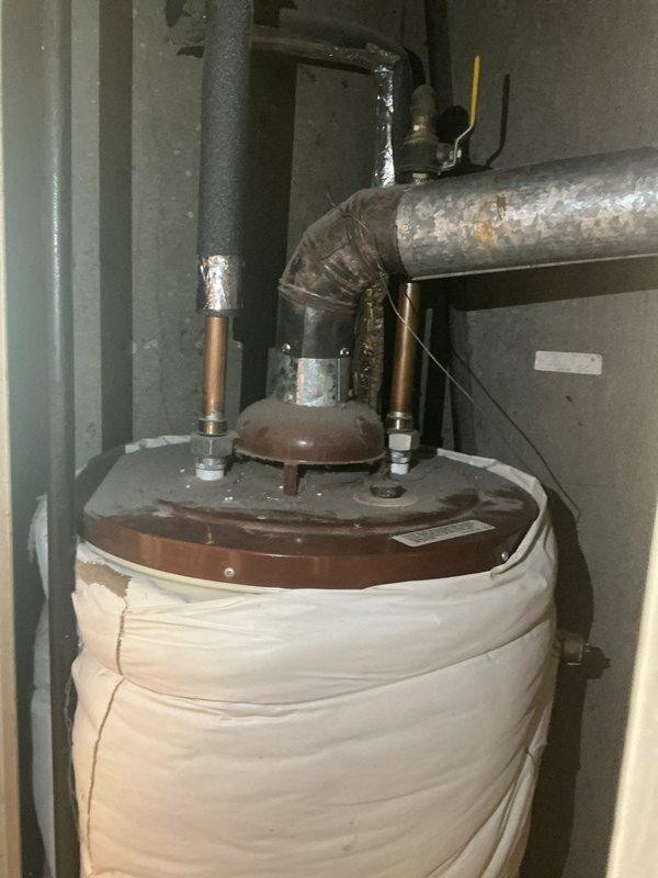 Installed 40-gallon short gas water heater with insulation blanket in utility closet. Installed 3/4" pressure reducing valve and 3/4" flare angle stop with copper supply lines and appropriate connections. Completed installation per University City permit requirements with all code-compliant fittings and proper venting.