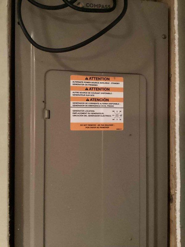Completed comprehensive electrical inspection of residential service panel and distribution system. Examined main electrical panel housing with standby generator interconnection labeling, verifying proper warning signage and access panel integrity. Inspected internal wiring configuration including multiple circuit conductors (red, black, white, and gray cables), verified proper wire bundling and organization, and confirmed secure wire nut connections on neutral conductors within the distribution box.