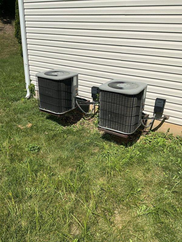 # HVAC Service Completed

Responded to a no cooling call for a two-unit residential system. Upon arrival, found the upstairs unit had been shut down by the homeowner due to evaporator coil freeze-up that occurred the previous night. Inspected both outdoor condensing units located on ground-level pads adjacent to the structure. 

Diagnosed the upstairs system experiencing frozen evaporator coil, likely caused by restricted airflow or low refrigerant charge. Confirmed unit was powered off to allow ice to thaw. Inspected ductwork installation in basement/crawl space area, noting standard galvanized metal trunk lines with proper support and insulation present at wall surfaces.

Evaluated both aging condensing units and discussed system condition with homeowner. Downstairs unit showing signs of age and declining performance, requiring potential replacement in near future. Provided preventive maintenance agreement options to address ongoing system reliability concerns.

Documented equipment 