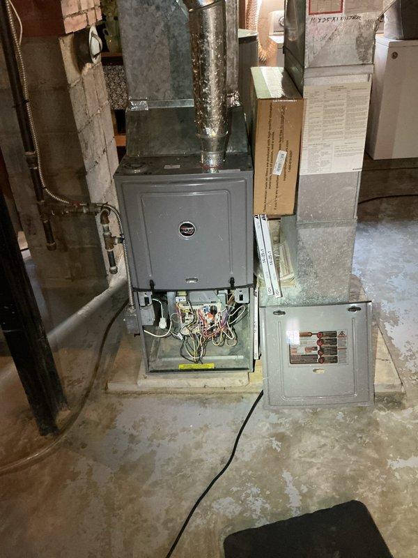 Responded to service call for furnace potentially damaged by water main break. Performed diagnostic inspection of basement-installed unit under 10 years old. Accessed internal components through lower panel to assess electrical connections, control boards, and wiring for water damage or moisture intrusion. Documented equipment condition with photographs showing furnace cabinet, ductwork connections, electrical panel, and internal wiring configuration. Evaluated all visible components for signs of water exposure, corrosion, or compromised connections resulting from reported water main break incident.