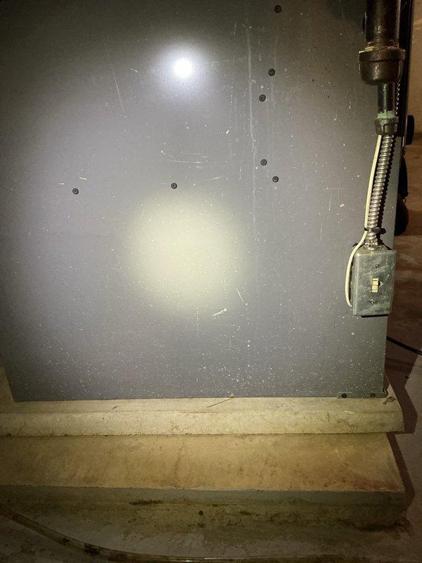 Responded to service call for furnace potentially damaged by water main break. Performed diagnostic inspection of basement-installed unit under 10 years old. Accessed internal components through lower panel to assess electrical connections, control boards, and wiring for water damage or moisture intrusion. Documented equipment condition with photographs showing furnace cabinet, ductwork connections, electrical panel, and internal wiring configuration. Evaluated all visible components for signs of water exposure, corrosion, or compromised connections resulting from reported water main break incident.