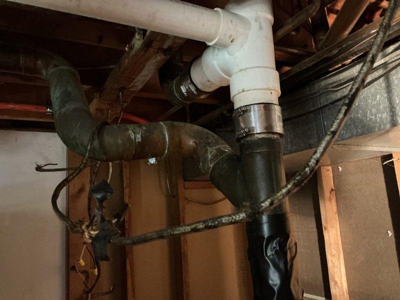 Responded to basement sewer line concern and performed inspection of downspout drainage system. Identified and replaced defective coupling connection between white PVC drain pipe and existing cast iron sewer line. Installed new flexible rubber coupling with stainless steel clamps to ensure proper seal and prevent future leakage. Verified all connections are secure and system is draining properly.