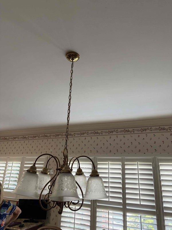 Removed existing brass chandelier with five frosted glass shades and installed customer-supplied ceiling-mounted ventilation fixture with integrated lighting in residential space. Additionally installed customer-supplied light switches as requested to complete the electrical upgrade.