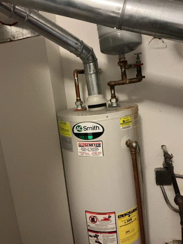 Responded to water leak in ceiling at condominium building. Removed existing failed water heater and installed new 40-gallon gas tall water heater with drain pan. Connected copper supply lines with brass fittings and shut-off valves to water heater inlet and outlet. Installed pressure relief valve and discharge piping per code requirements. Connected closet-vent system with proper venting configuration using galvanized ductwork. Applied required plumbing identification sticker and obtained permit compliance for installation. Tested all connections for leaks, verified proper gas combustion, and confirmed water heater operation. System functioning properly upon completion.