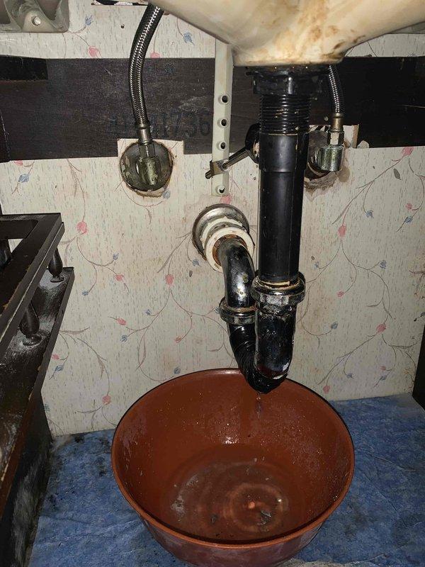 Responded to clogged bathroom sink caused by deteriorated P-trap assembly with visible corrosion at metal coupling and compromised pipe integrity. Removed failed trap section showing extensive mineral buildup and coating degradation, installed new P-trap assembly with proper sealing, and verified drainage flow restoration. Cleared standing water and confirmed all connections leak-free upon completion.