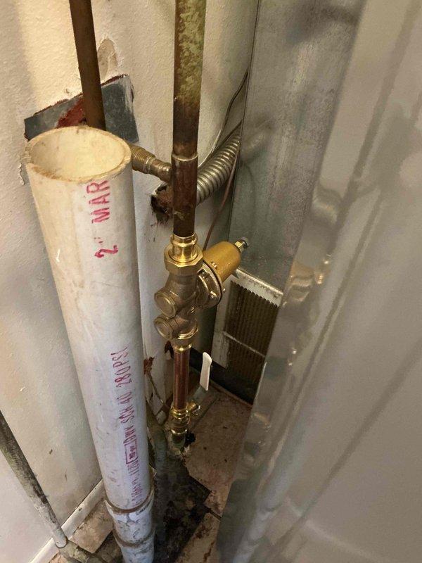 Installed a new 40-gallon electric water heater (47" x 20") in vacant apartment unit. Supplied and installed new 3/4" pressure reducing valve and main shut-off valve, then ran 3/4" copper piping from the water heater to the first hot water tee. Replaced powder room lavatory drain components including new PVC 45-degree elbow and P-trap assembly. Per customer request, kitchen sink water supply line was intentionally left disconnected as unit is undergoing remodeling.