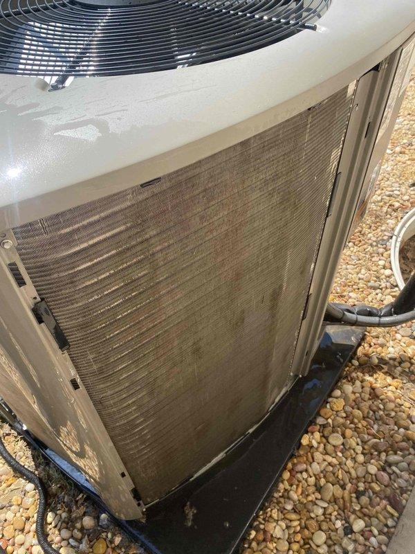 # HVAC Service Completed

Responded to a no cooling complaint affecting the entire home with a 13-year-old air conditioning system. Upon arrival, performed visual inspection of the outdoor condensing unit and identified severely restricted airflow due to heavily clogged condenser coil fins. The coil surfaces showed significant accumulation of dirt, dust, and debris throughout, causing brownish discoloration and blocking proper heat transfer.

Cleaned the condenser coil thoroughly to restore airflow through the fins and remove all accumulated contaminants. Following the cleaning, performed electrical diagnostics using a digital multimeter to verify system operation. Measured and recorded capacitor readings, confirming proper electrical component function with a reading of 2462 microfarads displayed on the meter.

Cycled the system and verified proper cooling operation was restored. The unit is now operating within normal parameters with adequate airflow across the condenser coil. Advise