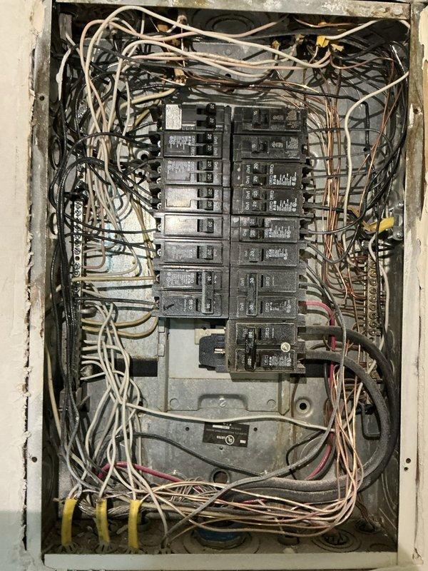 Completed electrical estimate for sub panel installation at residential property. Evaluated existing main electrical panel, which contains two columns of circuit breakers serving various household circuits including HVAC, water heater, kitchen appliances, bedrooms, and living areas. Observed dense wiring configuration with multiple wire runs and connections throughout the existing panel enclosure. Assessed current electrical load distribution and available capacity to determine specifications and requirements for proposed sub panel installation. Documented existing panel condition and circuit layout to develop accurate scope of work and material requirements for the sub panel project.