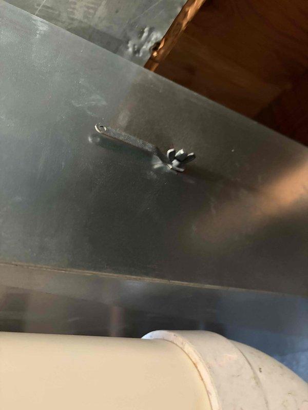 Responded to service call regarding Trane XL A50 thermostat displaying air cleaner mode and reports of insufficient airflow from multiple supply vents. Upon inspection, accessed attic space and examined HVAC ductwork system serving 10-year-old unit located at side of house. Investigated duct runs and plenum connections to identify potential airflow restrictions or disconnected ductwork that could cause reduced air delivery to affected rooms. Verified duct support straps and connections at main trunk line and branch ducts. Assessed thermostat settings and air cleaner mode functionality to determine if IAQ system was operating correctly or if control settings required adjustment. Documented ductwork configuration and condition with photos showing plenum assembly, metal duct installation, support brackets, and insulation placement in attic space.
