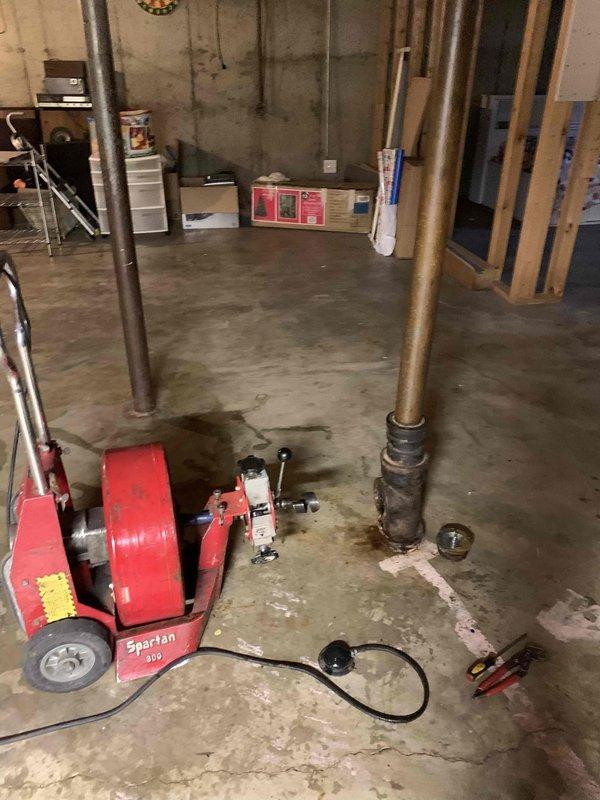 Responded to urgent basement flooding situation with water actively rising through floor drain. Upon arrival, found significant water accumulation on basement floor near laundry area with visible staining and moisture damage to concrete surface. Deployed Spartan motorized drain cleaning equipment to clear main sewer line obstruction causing backup. Successfully cleared blockage in basement drain system, restoring proper drainage flow and eliminating active water intrusion. Verified system functionality and confirmed water was draining properly through floor drain without further backup.