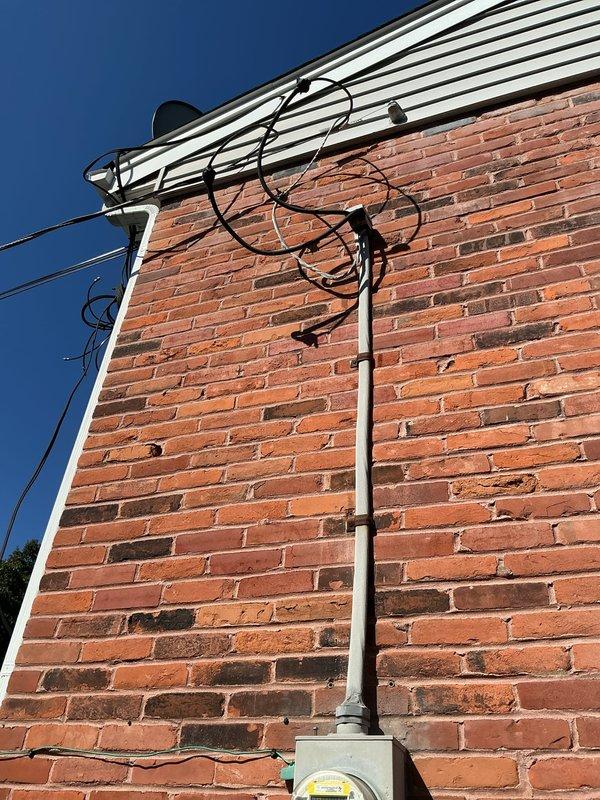 Relocated existing exterior electrical connection from shed-mounted position to fence post approximately four feet away. Disconnected and safely removed electrical components from original mounting location, repositioned hardware to new fence post mount, and reconnected all wiring to maintain proper service continuity. Verified secure installation and proper electrical function at relocated connection point.