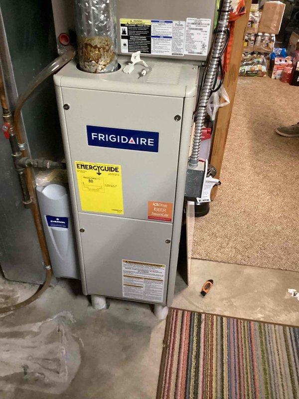 Responded to no cooling complaint affecting entire home with 12-year-old Frigidaire HVAC system. Upon arrival, performed comprehensive system diagnostics on indoor air handler unit located in basement utility area. Inspected furnace cabinet, ductwork connections, refrigerant lines, and electrical components. Noted visible corrosion at base of metallic supply duct connection point. Verified proper airflow through system, checked thermostat communication, and tested capacitor functionality. Documented equipment condition with photos showing installation configuration, manufacturer labels, and areas of concern including rust formation on ductwork interface. Confirmed best contact number for follow-up communication.