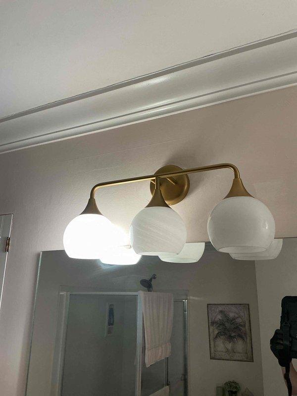 Responded to service call for flickering lights in bathroom vanity fixture. Upon arrival, diagnosed six-light brass fixture with only four operational bulbs after customer broke two during troubleshooting attempts. Tested electrical connections and determined flickering was caused by loose bulbs and improper contact. Advised customer that replacement bulbs are not stocked on service vehicle and must be provided by homeowner for this decorative fixture type with frosted globe shades. Verified proper voltage and confirmed fixture wiring and connections were secure with no electrical faults present.