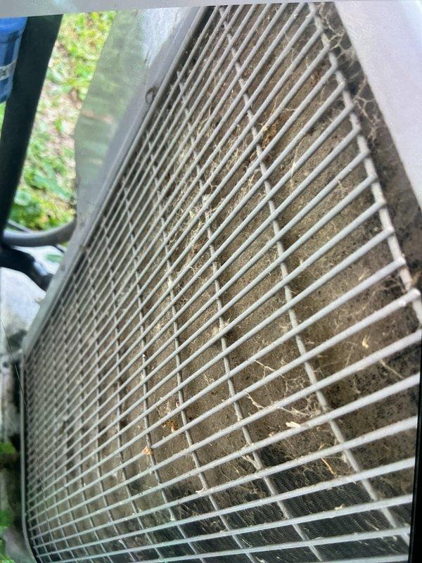 Responded to no cooling complaint on 5-year-old split system air conditioning unit. Upon inspection, found condenser coil heavily loaded with dirt, dust, and debris accumulation, significantly restricting airflow through fins. Cleaned condenser coil thoroughly to restore proper heat transfer and system efficiency. Inspected electrical components including capacitor and contactor, verified all connections secure and within specifications. Unit tested after service, confirmed adequate cooling operation and proper system function restored.