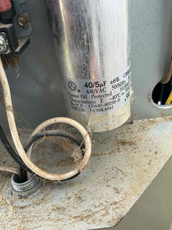 Responded to no cooling complaint on 2017 system. Upon arrival, found unit not operating efficiently with warm copper line at indoor coil indicating potential compressor or refrigerant issue. Performed diagnostic testing of outdoor unit components including amperage draw measurements using clamp meter, which revealed readings of approximately 70 amps. Inspected dual-run capacitor rated at 40/5 μF 440VAC, noting visible wear and discoloration on housing. Capacitor showed signs of age-related deterioration with accumulated debris on mounting surface. Documented electrical measurements and component conditions with photos for service records. Advised customer of findings and provided recommendations for necessary repairs to restore proper cooling operation.