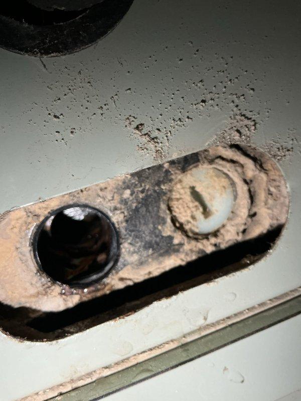 Responded to water leak complaint on 7-year-old Trane furnace system. Upon inspection, identified condensate drainage issue related to condensate pump malfunction. Temperature readings and visual inspection confirmed active leak condition with evidence of water damage to surrounding ceiling surfaces and mounting hardware showing significant corrosion. Documented extensive rust and deterioration on metal components, indicating prolonged moisture exposure. Addressed drainage blockage and restored proper condensate removal function. Verified system operation and confirmed leak resolved. Recommended monitoring for recurrence and consideration of affected component replacement due to corrosion damage.