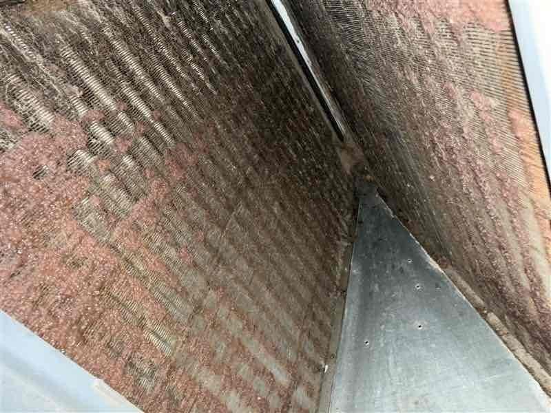Responded to no cooling complaint on 4-year-old residential air conditioning system. Upon arrival, found thermostat not functioning properly as previously reported in recall notice. Inspected evaporator coil assembly and discovered severe contamination with biological growth, dirt accumulation, and debris throughout coil fins, significantly restricting airflow and reducing heat transfer efficiency. Heavy pink and reddish-brown residue visible across entire coil surface, indicating mold and bacterial contamination. Documented coil condition with photos showing extensive discoloration and buildup on both A-frame sections of evaporator. Advised customer that thorough coil cleaning and thermostat replacement required to restore proper system operation and cooling capacity.