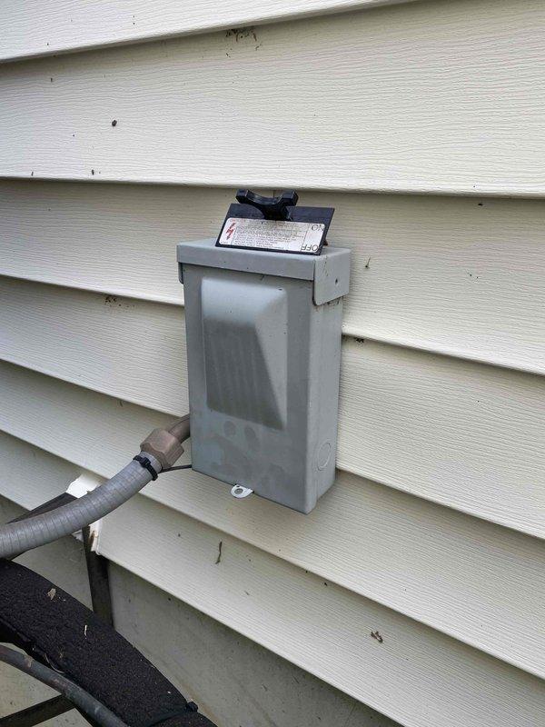 Completed callback service to address air conditioning system issues. Replaced flue pipe with proper elbow fitting to ensure correct venting configuration. Performed thorough cleaning of outdoor condenser unit by hosing down coils and exterior components to remove debris and improve heat transfer efficiency. Verified system operation with temperature readings showing 59.4°F at evaporator coil. Documented electrical disconnect box installation and overall system condition through photographs for service records. Removed and disposed of old flue pipe materials from site.