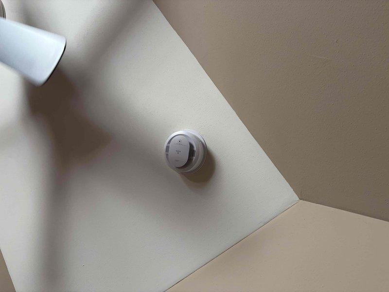 Replaced outdated smoke detector with customer-provided unit at ceiling location near corner junction. Removed existing detector, installed new device, and verified proper mounting and functionality. No additional electrical issues observed during installation.