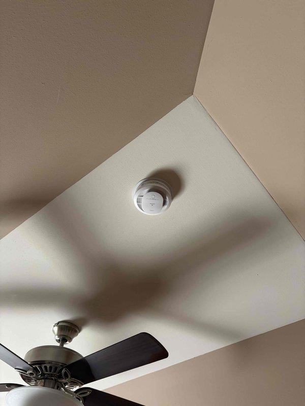 Replaced outdated smoke detector with customer-provided unit at ceiling location near corner junction. Removed existing detector, installed new device, and verified proper mounting and functionality. No additional electrical issues observed during installation.
