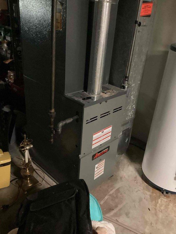 Responded to no cooling complaint on 10+ year old residential air conditioning system located at side of house. Upon arrival, provided courtesy call per special instructions and proceeded to basement mechanical room for diagnostic evaluation. System was operational but delivering room temperature air with no cooling capacity. Performed comprehensive system assessment including inspection of furnace, air handler, and associated components. Verified thermostat settings and confirmed call for cooling. Checked electrical connections, control board operation, and safety switches. Inspected condensate drainage system and refrigerant lines. Evaluated indoor coil condition and airflow characteristics. Documented equipment nameplate information and captured photographic evidence of installation for service records. System requires further diagnosis of outdoor condensing unit to determine root cause of cooling failure, which may include compressor malfunction, refrigerant leak, or electrical com