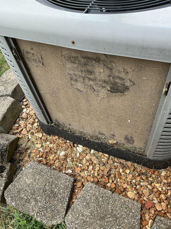 Responded to service call for outdoor AC unit experiencing intermittent banging noise. Upon arrival, unit had been shut off by homeowner as a safety precaution. Performed comprehensive inspection of condenser unit and discovered severely contaminated base filter/panel with significant dirt accumulation and discoloration. Removed access panel to assess internal components and filter condition. Documented equipment condition with photos showing heavy debris buildup on filtration material and weathered components. The contaminated filter and debris accumulation were identified as likely contributors to the reported banging noise, as restricted airflow can cause pressure imbalances and component vibration within the system.
