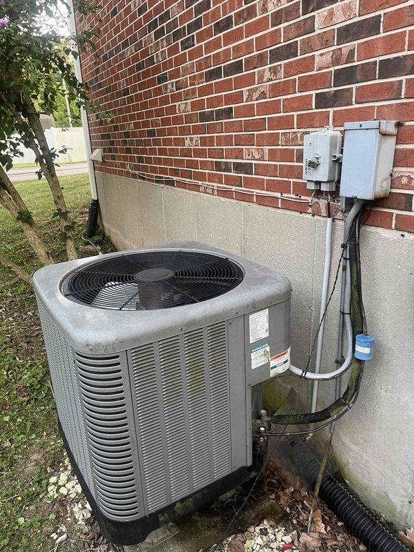 Responded to no cooling complaint on 9-year-old Rheem system with indoor temperature at 83°F despite thermostat set to 68°F. Upon arrival, performed visual inspection of outdoor condenser unit and refrigerant lines. Observed oxidation on copper refrigerant lines and brazed connections, indicating system age and potential refrigerant circuit concerns. Inspected condenser unit exterior components including fan assembly, electrical disconnect, and conduit connections. Documented current system condition with photographs showing refrigerant line configuration, filter-drier or accumulator component, and overall equipment placement. Noted copper line discoloration patterns consistent with extended service life. Evaluated electrical connections at disconnect box and traced conduit to unit. System assessment revealed need for further diagnostic testing to determine root cause of cooling failure, which may include refrigerant charge verification, compressor operation analysis, or airflow evalua