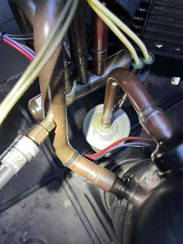 Responded to no cooling complaint on 9-year-old Rheem system with indoor temperature at 83°F despite thermostat set to 68°F. Upon arrival, performed visual inspection of outdoor condenser unit and refrigerant lines. Observed oxidation on copper refrigerant lines and brazed connections, indicating system age and potential refrigerant circuit concerns. Inspected condenser unit exterior components including fan assembly, electrical disconnect, and conduit connections. Documented current system condition with photographs showing refrigerant line configuration, filter-drier or accumulator component, and overall equipment placement. Noted copper line discoloration patterns consistent with extended service life. Evaluated electrical connections at disconnect box and traced conduit to unit. System assessment revealed need for further diagnostic testing to determine root cause of cooling failure, which may include refrigerant charge verification, compressor operation analysis, or airflow evalua