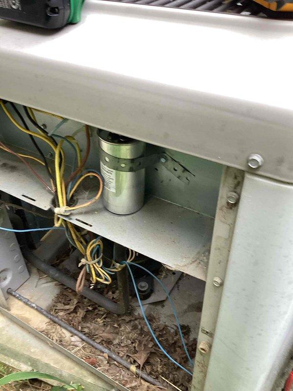 Responded to no cooling complaint on 27-year-old Carrier air conditioning system that ceased operation during extreme heat event. Upon inspection, found significant debris accumulation including leaves and dirt in lower compartment of air handler unit, along with visible wiring throughout cabinet. Documented existing equipment configuration in basement utility area alongside 12-year-old Lennox furnace and water heater. System requires further diagnostic evaluation and cleaning to restore proper airflow and cooling function.