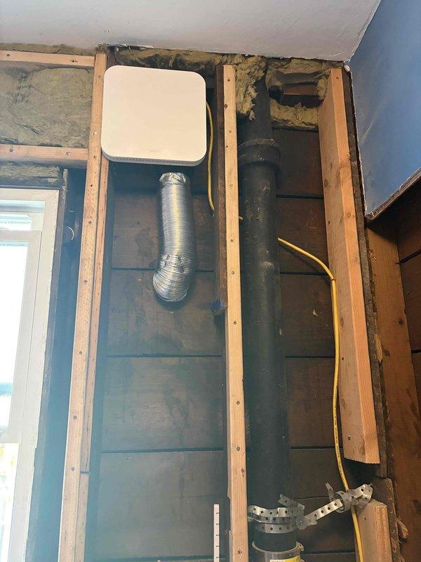 Completed installation of exhaust fan system including ductwork routing through wall cavity and attic space. Installed ventilation cover, connected flexible aluminum duct with proper support and sealing, and verified electrical connections at junction box to ensure safe operation of new exhaust fan unit.