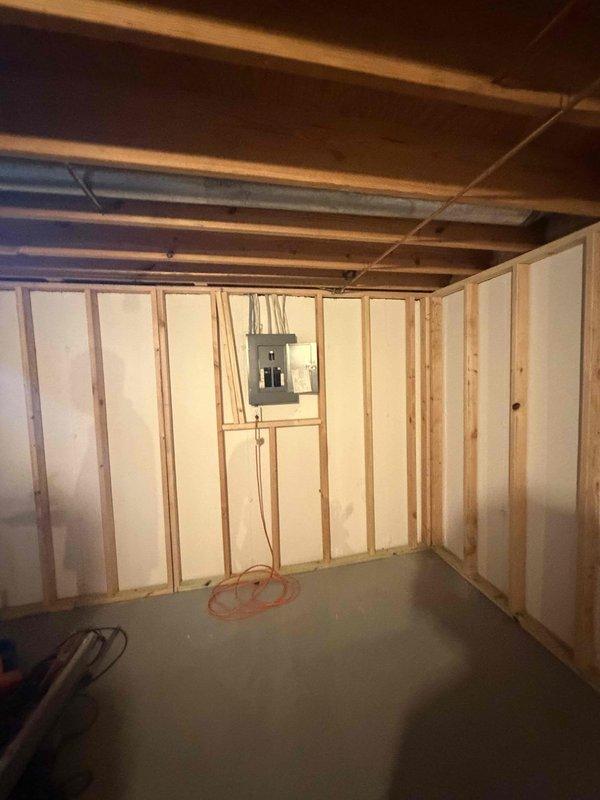 Completed comprehensive electrical rewiring of basement space, installing new circuit wiring for outlets and lighting fixtures throughout the unfinished area. Work included running new conductors through exposed wall framing to electrical panel, establishing proper branch circuits for receptacles and light fixtures, and ensuring all wiring met current electrical code requirements. All circuits were properly terminated at the main panel with appropriate breaker protection, with rough-in wiring positioned within stud bays for future drywall installation.