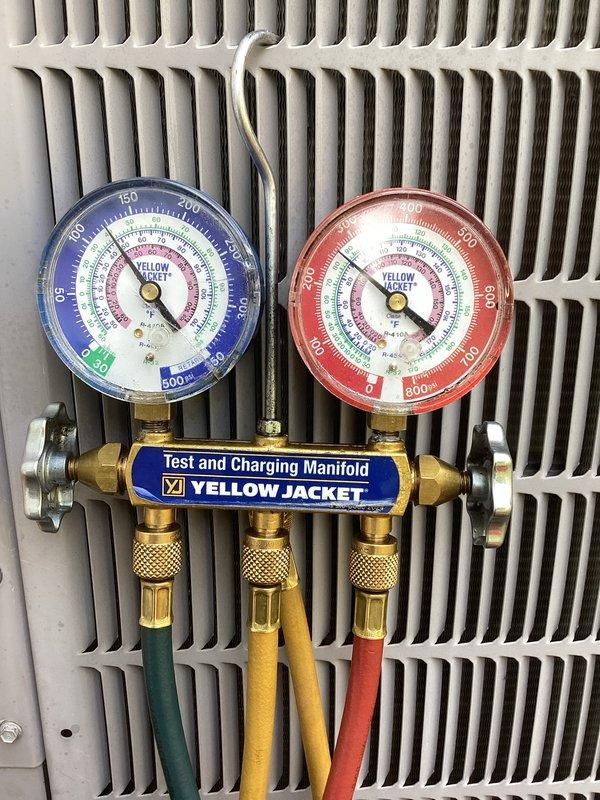 Completed comprehensive tune-up service on a 5-year-old residential air conditioning system with condenser unit located at ground level in side yard. Inspected and replaced air filter, performed refrigerant pressure testing using manifold gauges to verify proper system charge and operation, and confirmed all components functioning within manufacturer specifications.