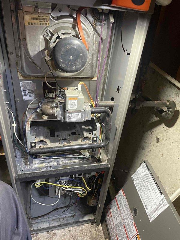 # HVAC Furnace Tune-Up - Home Depot Service

Performed comprehensive tune-up and inspection on residential forced-air furnace system located in garage utility room. Conducted thorough examination of all major components including blower motor assembly, gas valve with multi-wire connections, burner assembly, and heat exchanger sections. Inspected electrical connections throughout the unit, verifying proper wiring integrity on all circuits. Evaluated burner operation and combustion chamber condition. Assessed overall system functionality and verified safe operation of all heating components. Documented equipment condition through photographic records showing internal cabinet components and external unit housing with ventilation grilles. Noted minor dust accumulation in lower cabinet area typical of operational systems. All safety labels and manufacturer warnings confirmed present and legible. Unit operational and performing within normal parameters upon completion of tune-up service.