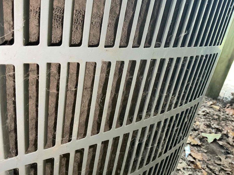 Responded to no cooling complaint on ground-level outdoor unit with recurring blown fuse issue from previous visit. Upon inspection, found condenser coils heavily clogged with dirt, dust, and debris causing restricted airflow and system overload. Inspected electrical disconnect box and confirmed cartridge fuses were functioning properly after previous replacement. Cleaned condenser coils to restore proper airflow and prevent future electrical overload conditions. Tested system operation and verified proper cooling function restored. Per customer request, left thermostat fan in ON position with AC system off.