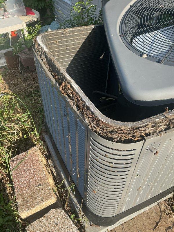 Completed preventive maintenance tune-up on single residential air conditioning unit located at rear of property. Removed significant accumulation of leaves, twigs, and organic debris from exterior condenser unit that had collected around perimeter and top edges. Inspected and serviced indoor air handler component, including air filter assessment. Unit returned to proper operating condition following standard tune-up protocol per Home Depot maintenance program specifications.