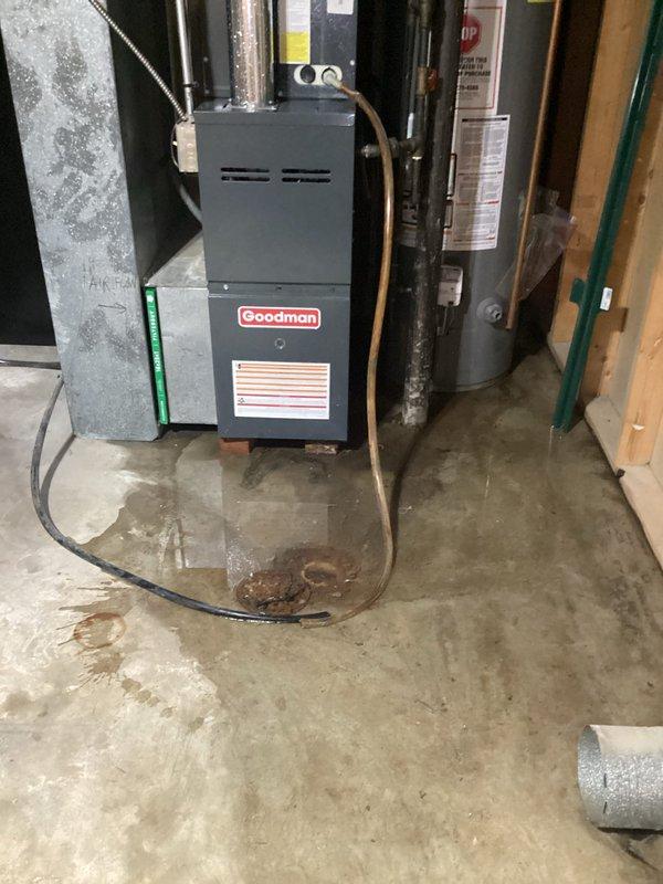 Responded to call for water leaking from AC drain line in basement. Upon arrival, found significant water accumulation on concrete floor around furnace and HVAC system. Inspected condensate drain system and identified clogged drain line causing overflow. Cleared blockage from drain line, verified proper drainage flow, and tested system operation. Checked refrigerant pressures and temperatures on outdoor unit to confirm AC system was functioning within normal parameters. System restored to proper operation with condensate draining correctly and no further leakage observed.