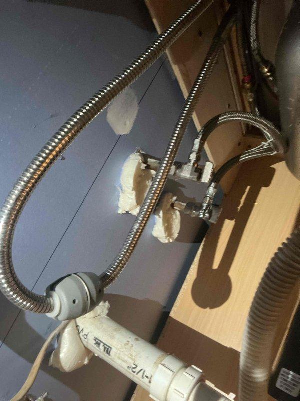 Completed recall service at vacant apartment property to address incomplete initial installation. Successfully installed 2 main water lines that were previously omitted, restoring full water shutoff capability. Provided and installed 40-gallon electric water heater (47" x 20"), new 3/4" pressure reducing valve with main stop, and ran 3/4" copper line to first hot tee after water heater. Replaced PVC 45-degree fitting and trap assembly for powder room lavatory. Per customer request, left kitchen sink water line disconnected due to ongoing remodeling work. All plumbing connections tested and operational, with main water control now fully functional.