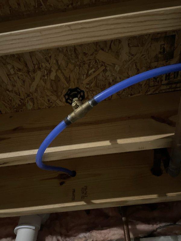 Responded to service callback regarding basement flooding that occurred during previous AC maintenance visit. Upon arrival, documented extensive water damage throughout basement area with visible pooling, moisture staining, and mineral deposits on concrete floor. Customer belongings showed water damage. Investigated source of flooding and inspected water supply connection at HVAC unit, locating blue flexible water line with shutoff valve in attic/crawl space above affected area. Photographed damage extent and plumbing connections for incident documentation. Verified current system operation and confirmed no active leaks present at time of callback inspection.